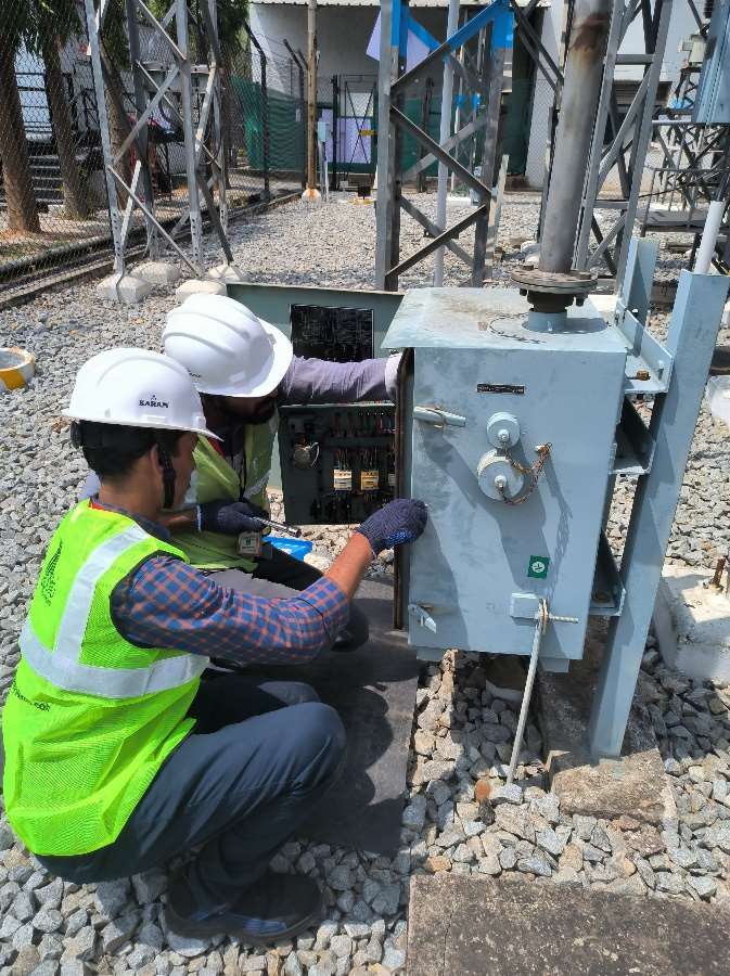 Engineer in safety gear testing substation equipment